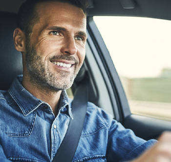 Man in blue shirt driving happily