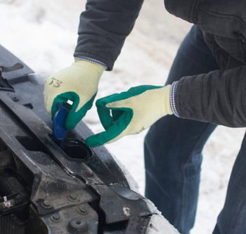 person checking their car engine during the winter