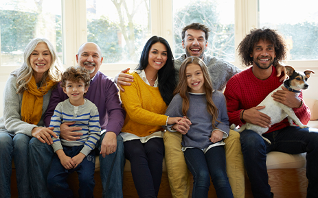 Five adults, two children, and a dog posed together