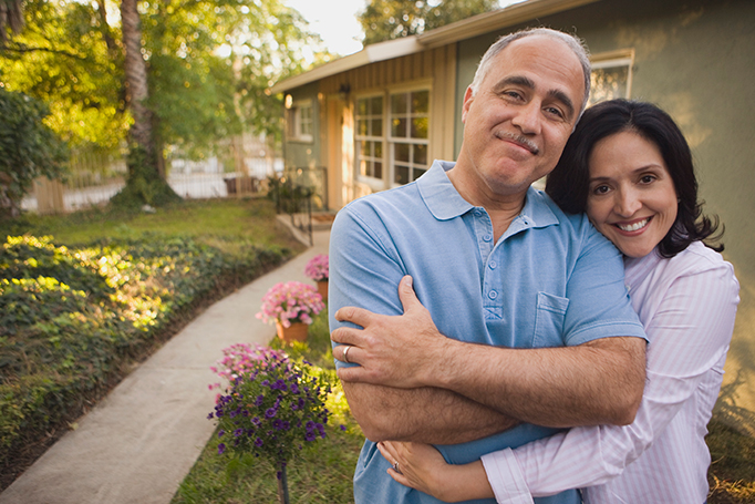 Woman hugging man in front of their home