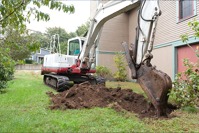 Excavator digging in someone's backyard